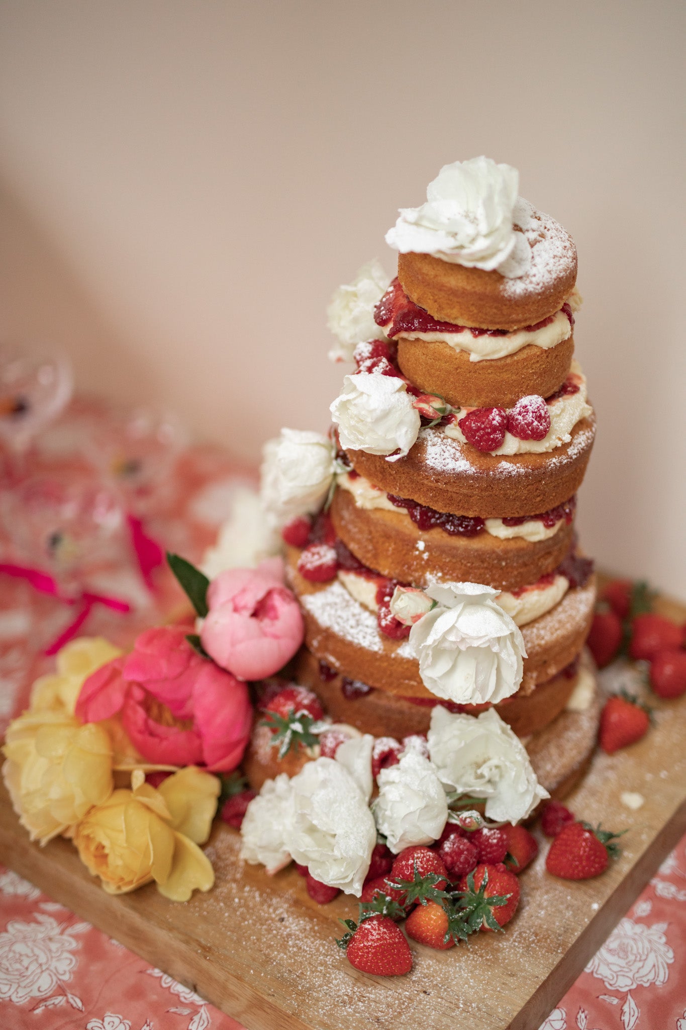 Naked flower sponge cake with berries, roses and peonies